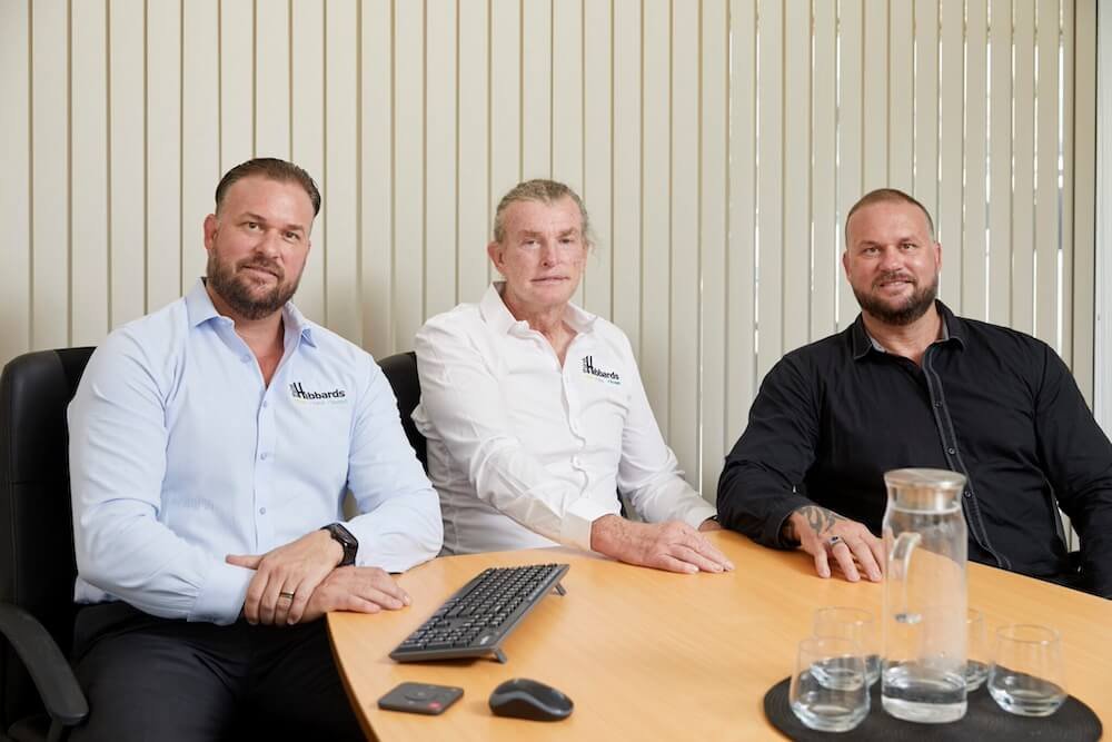 bruce hibbard with sons michael and josh hibbard sitting in a boardroom Bruce Hibbard and his sons Michael and Jon Hibbard keep the family legacy of Hibbard Homes alive